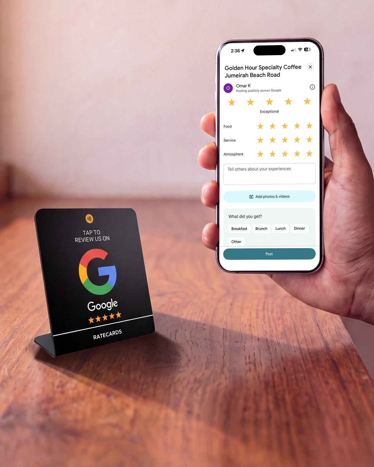 RATECARDS Google Review Stand Premium Black on a counter next to a phone